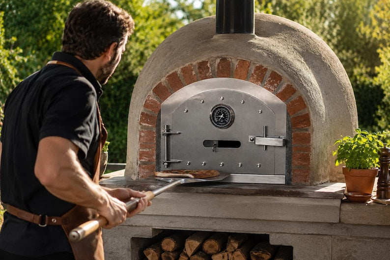 Dome-shaped outdoor pizza oven with stainless steel door